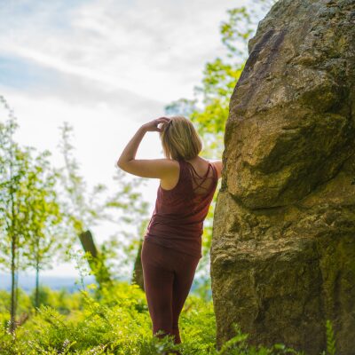 Erika Stalder | ganzheitlicher yoga Frau stützt sich an einem Baum. Linke Hand ist am Kopf