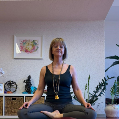 Erika Stalder ganzheitlicher yoga Hände zeigen ein Mudra und halten eine Blüte